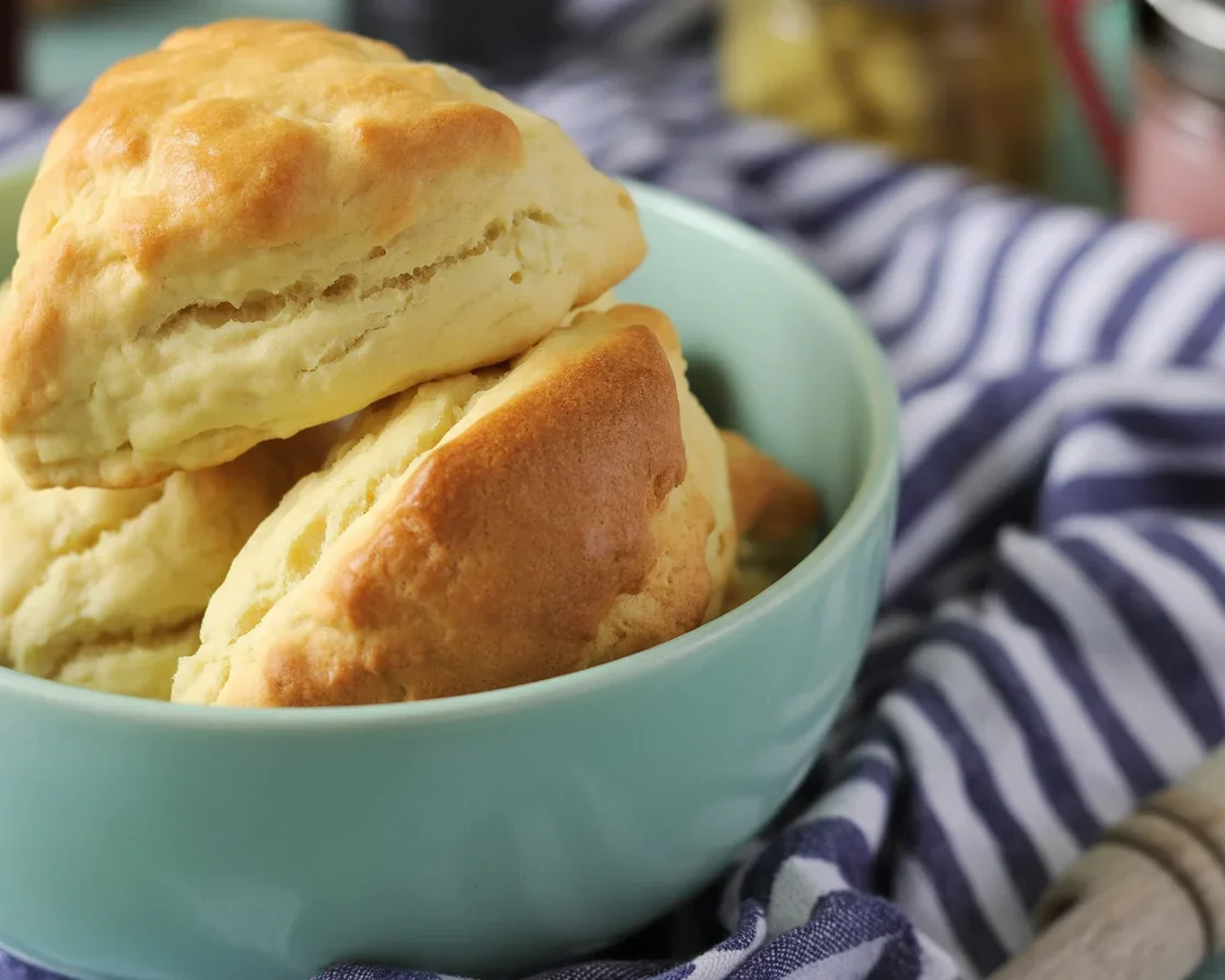 Freshly baked buttermilk scones on a plate with jam and butter