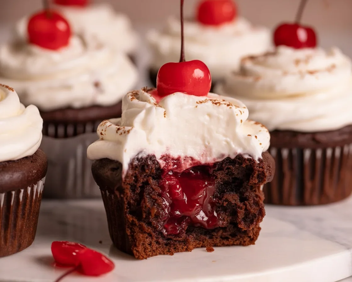 Decadent Black Forest Muffins topped with cherry filling and whipped cream.